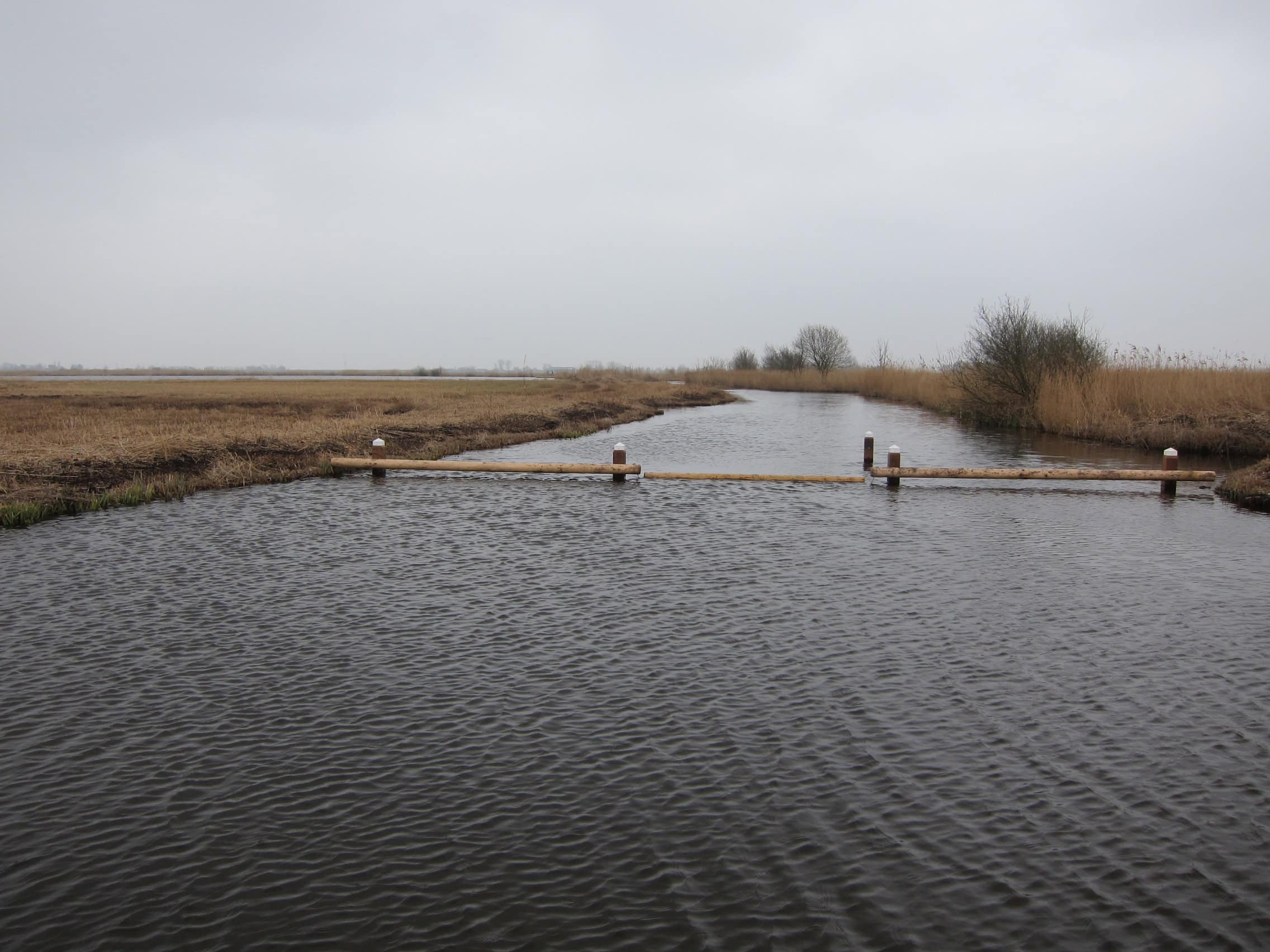 Voorbeeld van hoe het recreatieve netwerk functioneert om de balans tussen recreatie en natuur te bewaren. De drijfbalk sluit een sloot richting een kwetsbaar natuurgebied af voor vaarverkeer in Waterland-oost bij het dorp Zuiderwoude.